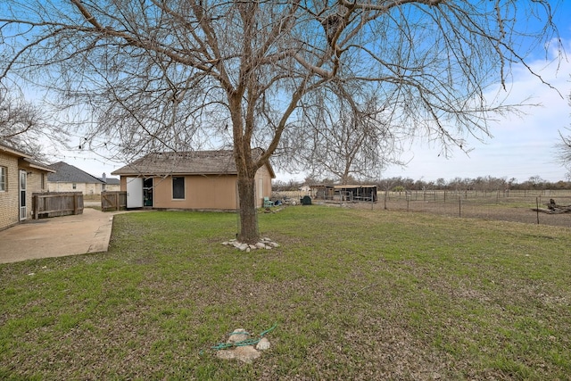 view of yard featuring an outbuilding, a patio, and a rural view