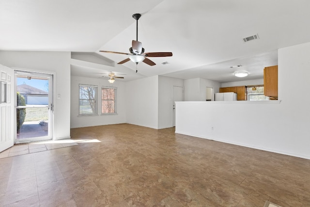 unfurnished living room with ceiling fan, a healthy amount of sunlight, and vaulted ceiling