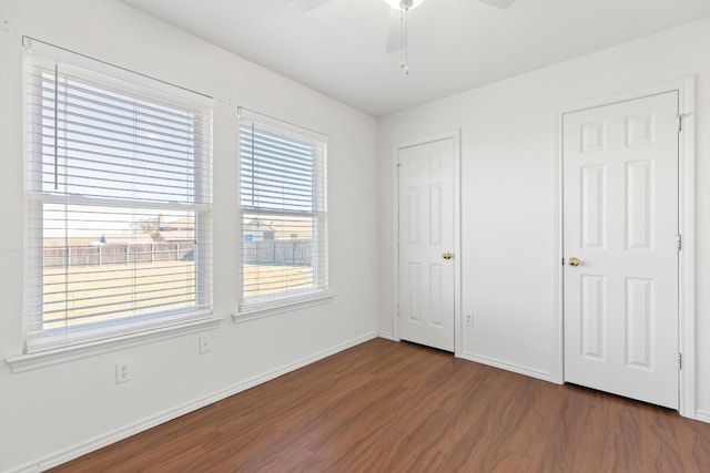 unfurnished bedroom featuring ceiling fan and dark wood-type flooring