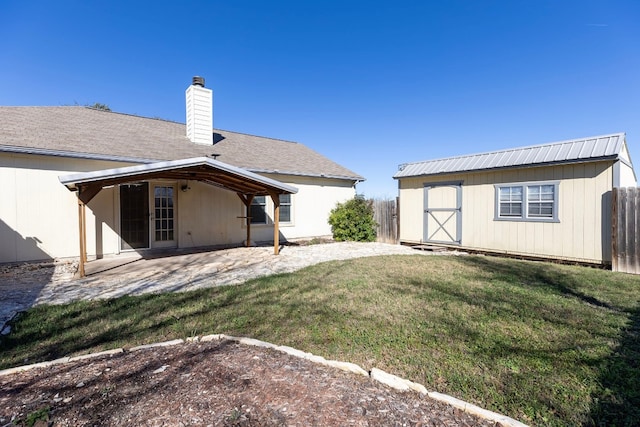 rear view of house featuring a lawn, a storage shed, and a patio