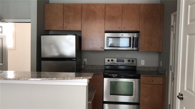 kitchen with dark stone countertops and stainless steel appliances