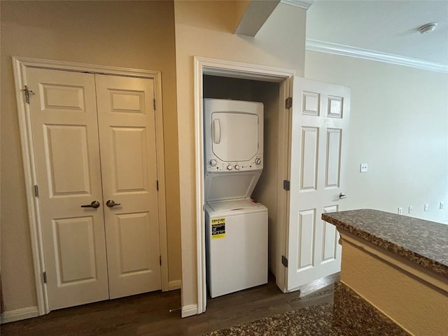 washroom with stacked washer / drying machine, dark wood-style floors, laundry area, and crown molding