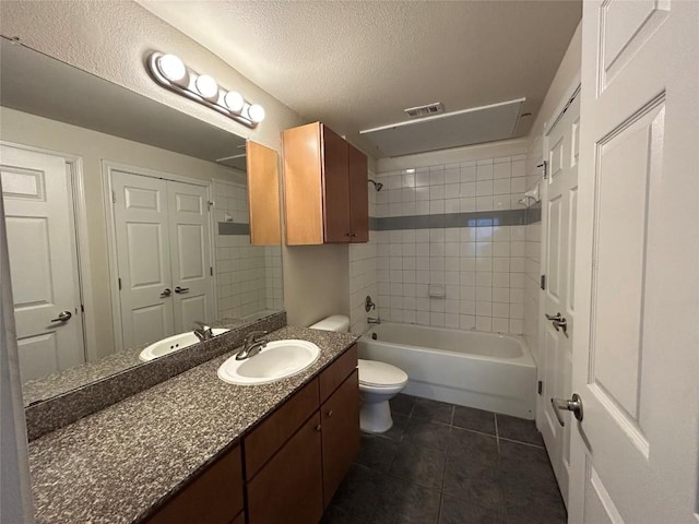 full bath featuring tub / shower combination, toilet, vanity, tile patterned floors, and a textured ceiling