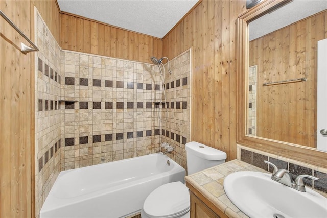 7209 Gunnison Pass, Austin, TX 78724 - bathroom with toilet, vanity,  shower combination, a textured ceiling, and wooden walls