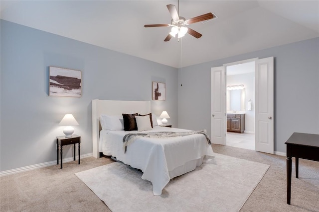 carpeted bedroom with ceiling fan, lofted ceiling, and connected bathroom