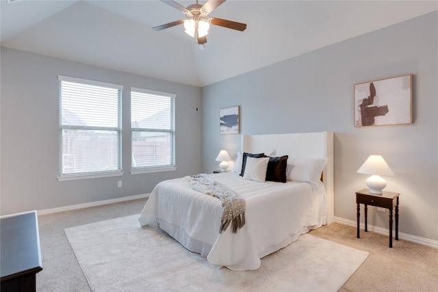 carpeted bedroom with multiple windows, ceiling fan, and vaulted ceiling