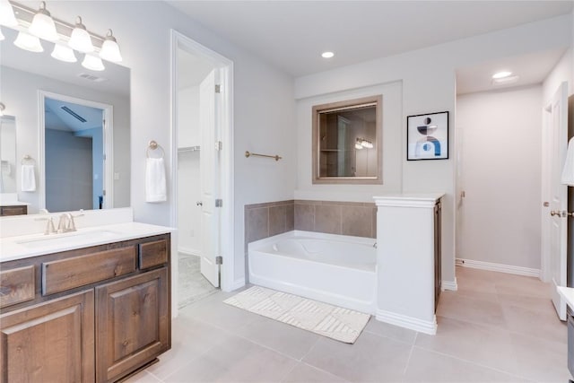 bathroom with tile patterned floors, vanity, and a tub to relax in