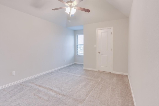 carpeted spare room featuring ceiling fan and vaulted ceiling