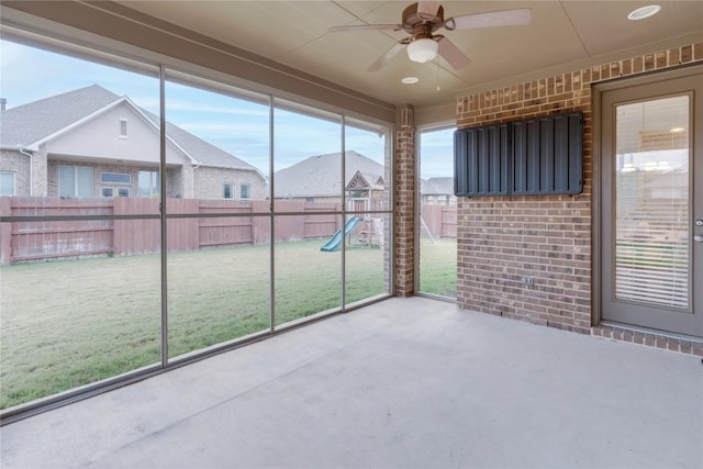 unfurnished sunroom featuring ceiling fan