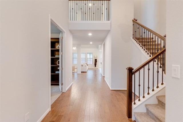 entrance foyer featuring light hardwood / wood-style flooring and a high ceiling