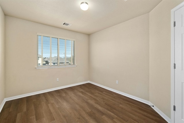 spare room with dark hardwood / wood-style flooring