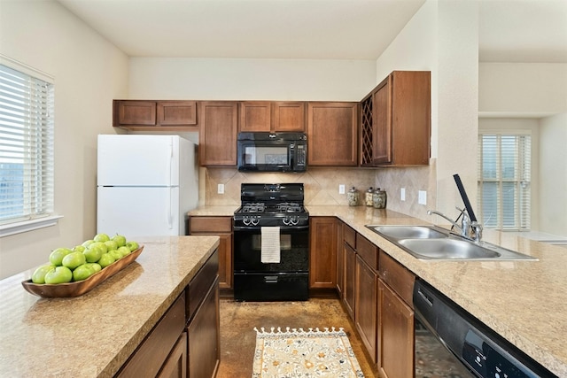 kitchen with black appliances, backsplash, a healthy amount of sunlight, and sink