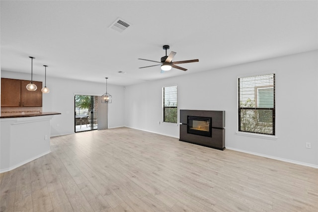 unfurnished living room with ceiling fan, a healthy amount of sunlight, and light hardwood / wood-style floors