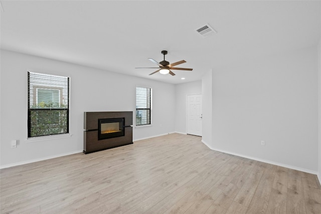 unfurnished living room featuring light hardwood / wood-style flooring, plenty of natural light, and ceiling fan