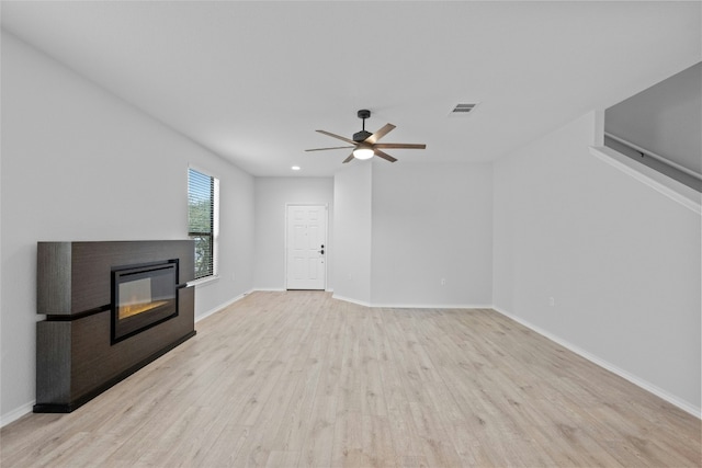 unfurnished living room with light hardwood / wood-style flooring and ceiling fan