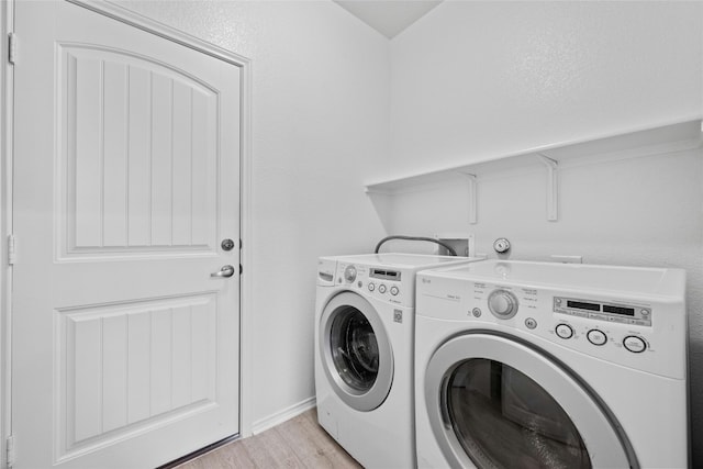 washroom with washer and dryer and light wood-type flooring