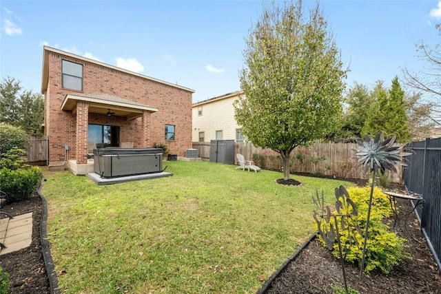 back of property featuring a lawn, central AC, and a hot tub