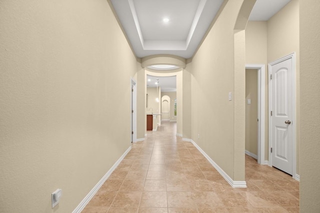 hall featuring a tray ceiling