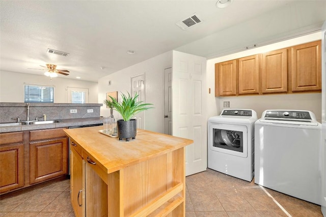 laundry area with washing machine and dryer, ceiling fan, sink, and light tile patterned flooring