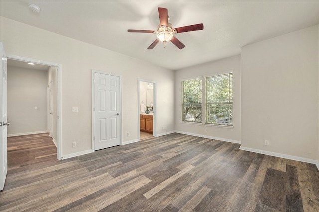 unfurnished bedroom with ensuite bath, ceiling fan, and dark wood-type flooring