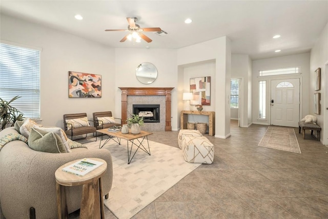 living room with ceiling fan, a fireplace, and light tile patterned floors