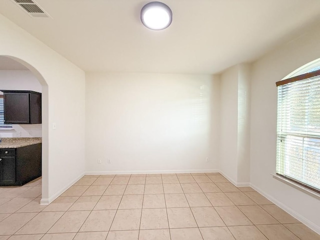 tiled spare room featuring a wealth of natural light