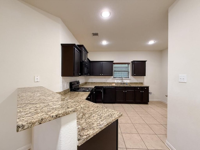 kitchen featuring kitchen peninsula, light stone countertops, sink, black appliances, and light tile patterned flooring