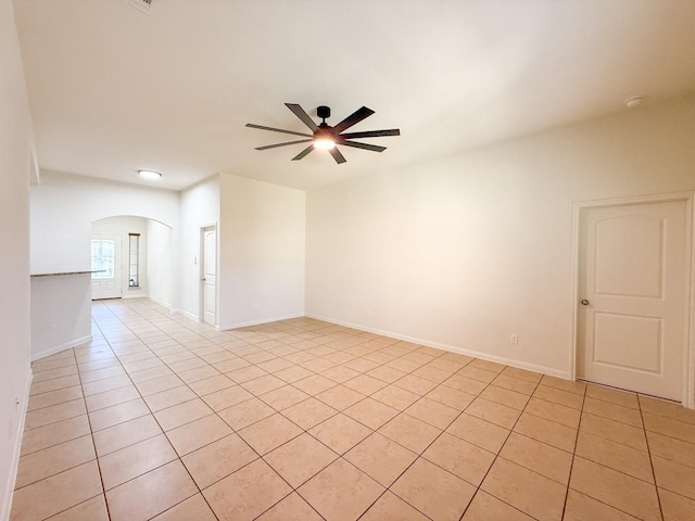 tiled empty room featuring ceiling fan