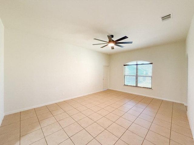 empty room with ceiling fan and light tile patterned flooring