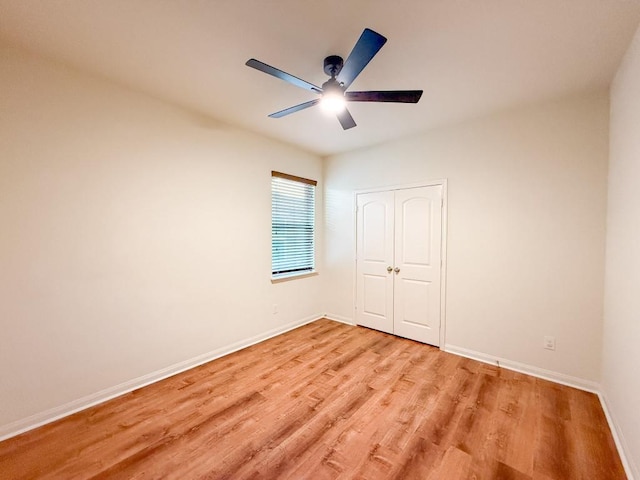 unfurnished bedroom with ceiling fan, a closet, and light wood-type flooring