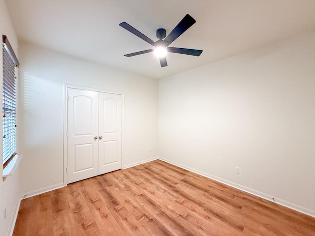 unfurnished bedroom with ceiling fan, light hardwood / wood-style floors, and a closet