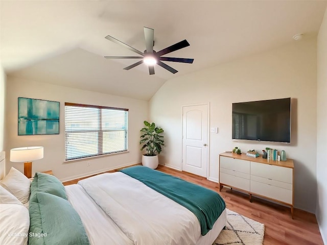 bedroom featuring ceiling fan, lofted ceiling, and light wood-type flooring