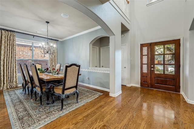 dining area featuring hardwood / wood-style flooring, crown molding, and a chandelier