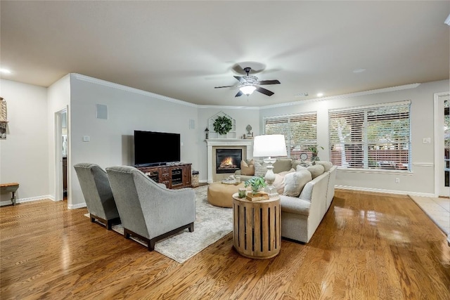 living room featuring ceiling fan, light hardwood / wood-style floors, and ornamental molding