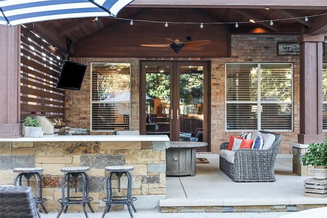 view of patio / terrace with a bar, an outdoor hangout area, and ceiling fan