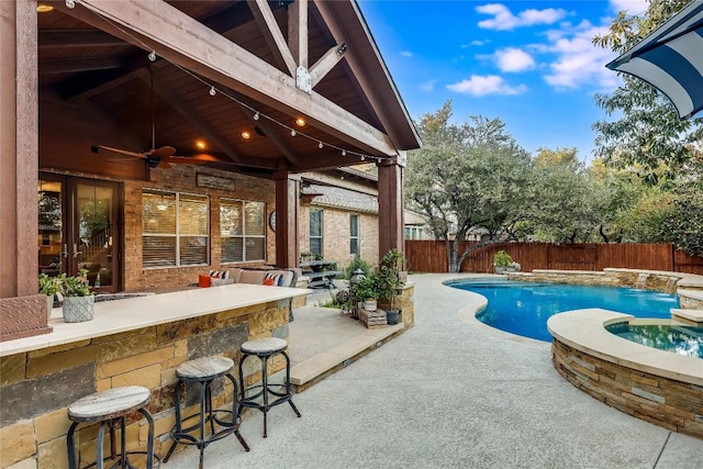 view of pool with ceiling fan, an outdoor bar, an in ground hot tub, and a patio