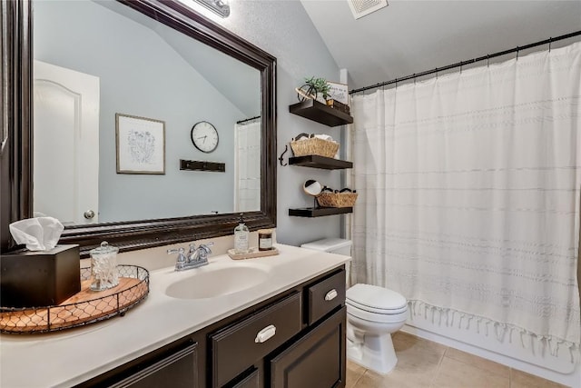 bathroom with tile patterned flooring, vanity, vaulted ceiling, and toilet