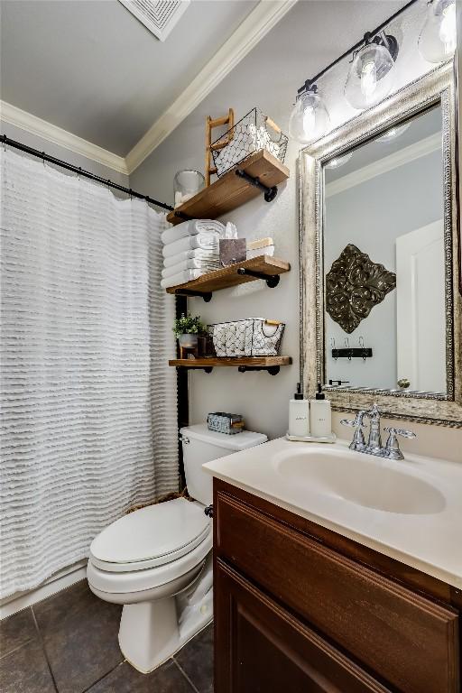 bathroom with toilet, vanity, tile patterned floors, and ornamental molding