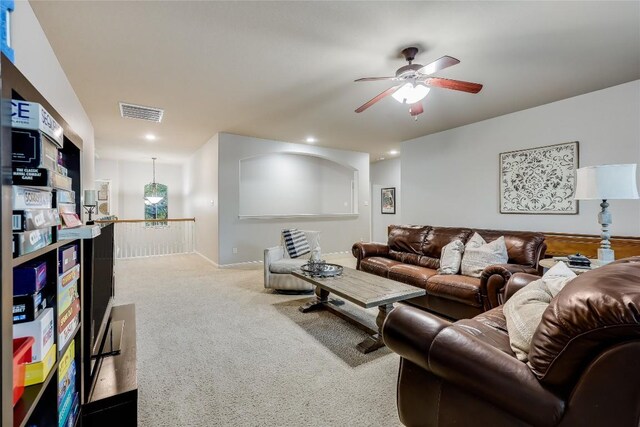 carpeted living room with ceiling fan