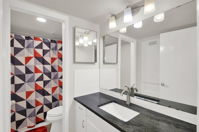 bathroom featuring vanity and toilet