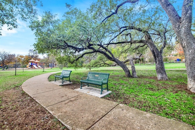 view of property's community with a playground and a yard