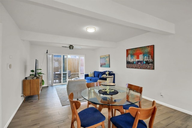 dining room with beam ceiling, ceiling fan, and wood-type flooring