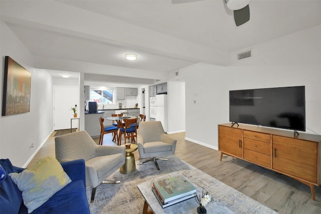 living room featuring ceiling fan and light hardwood / wood-style floors