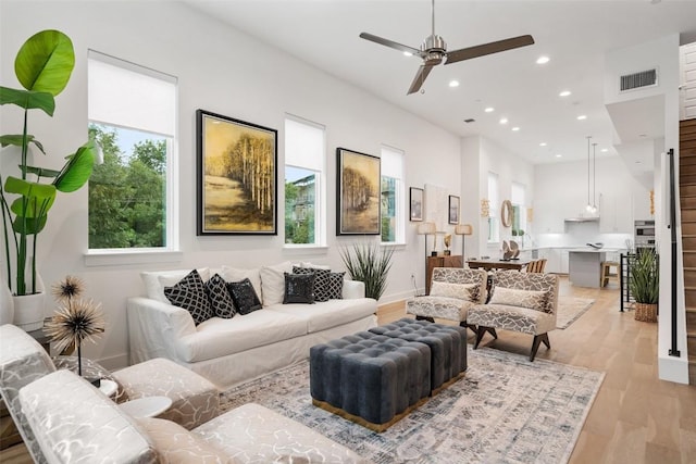 living room featuring ceiling fan and light hardwood / wood-style floors