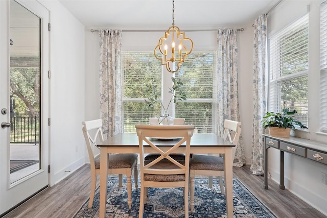 dining space featuring wood-type flooring and an inviting chandelier