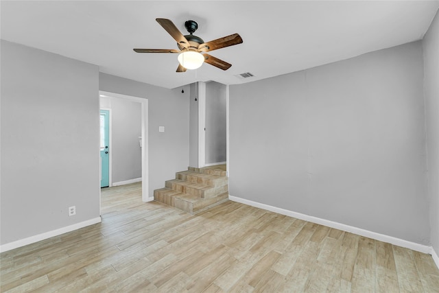 empty room with ceiling fan and light hardwood / wood-style flooring