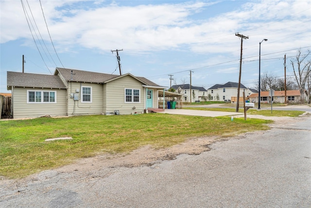 exterior space featuring a front lawn and a carport