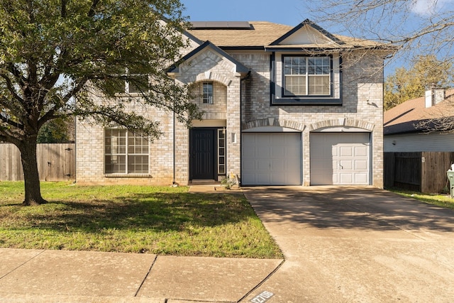 view of front of home with solar panels, a garage, and a front yard