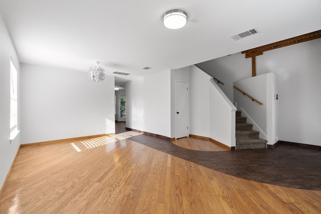 spare room featuring hardwood / wood-style flooring and a chandelier