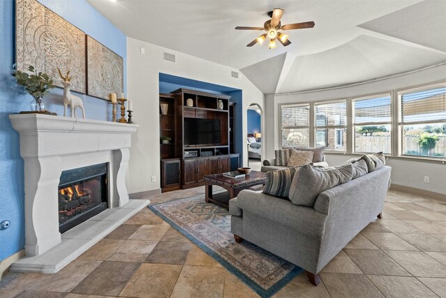 living room with built in shelves, vaulted ceiling, and ceiling fan